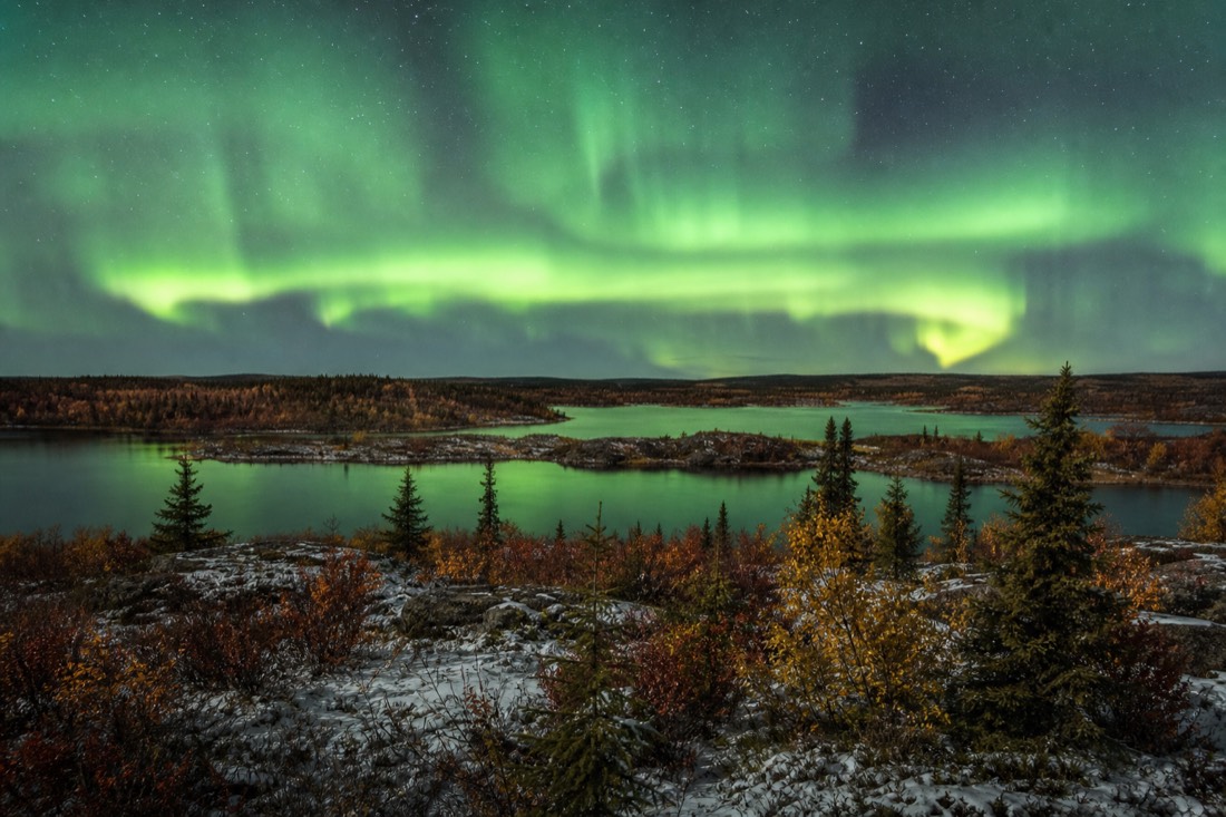 Autumn colors in gold and rust across low tundra and lakes outside Yellowknife