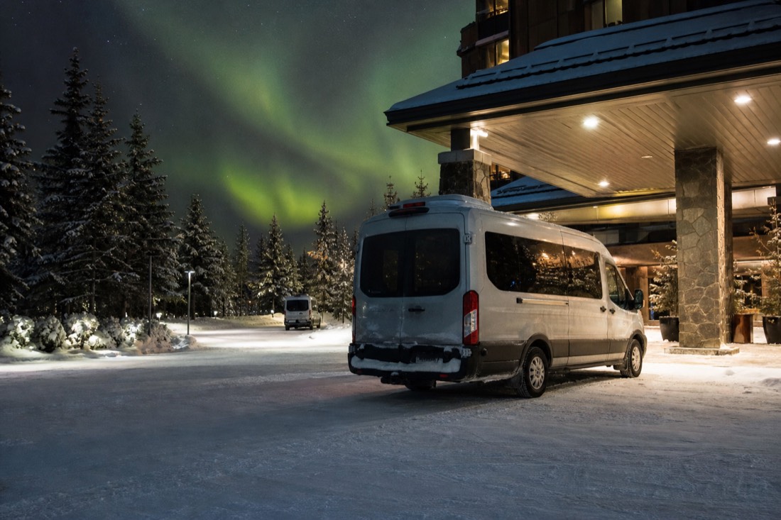 Tour van waiting outside a downtown Yellowknife hotel entrance on a snowy winter evening