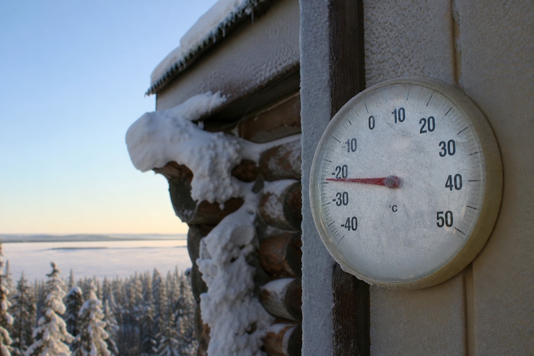 Thermometer on a frosted cabin wall reading deep below minus twenty on a clear Yellowknife morning