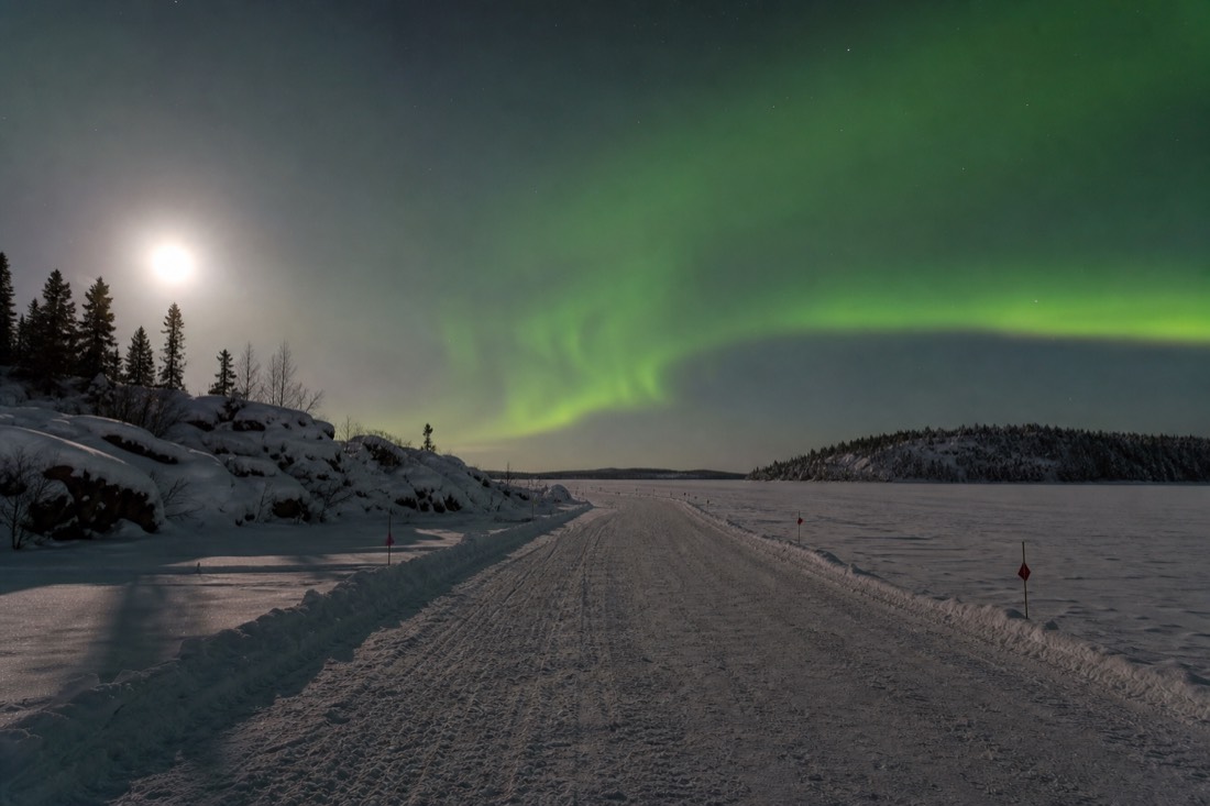 Marked Dettah ice road crossing the frozen bay near Yellowknife with packed snow lanes and small marker flags
