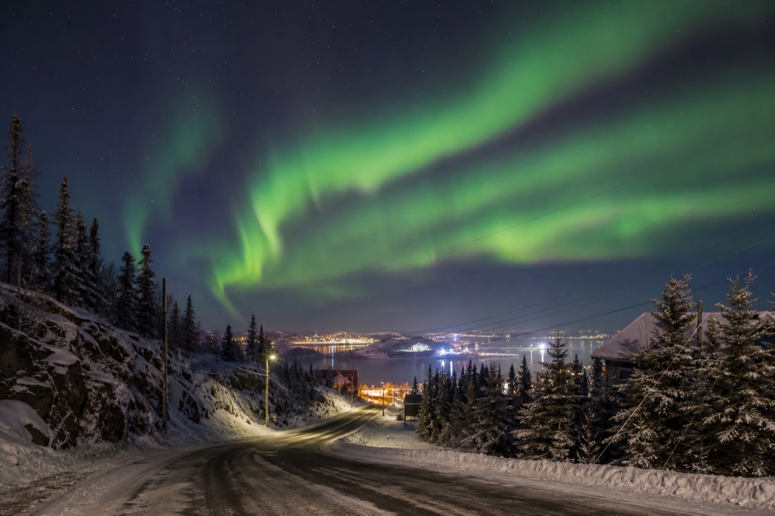 The road descending from downtown Yellowknife toward the log cabins and waterfront of Old Town