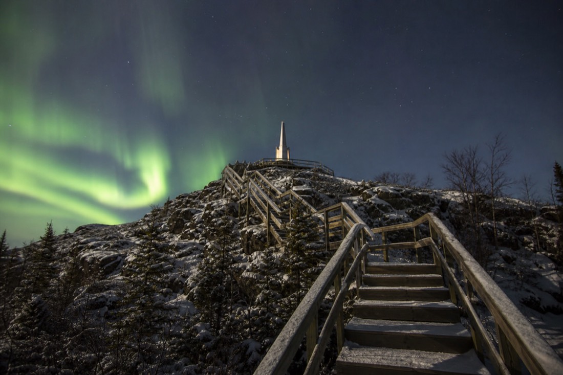 Wooden staircase climbing the bare rock outcrop toward the Bush Pilots Monument above Old Town Yellowknife