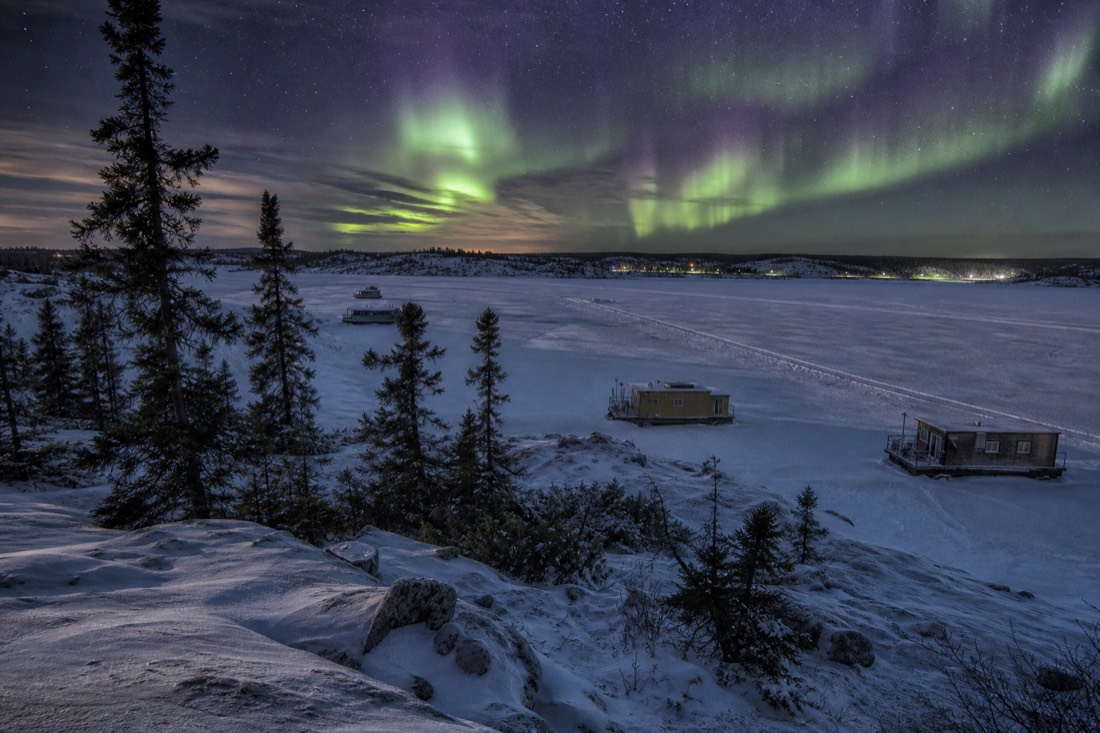 Frozen Yellowknife Bay seen from Old Town with houseboats locked in the ice and the plowed ice road crossing toward Dettah