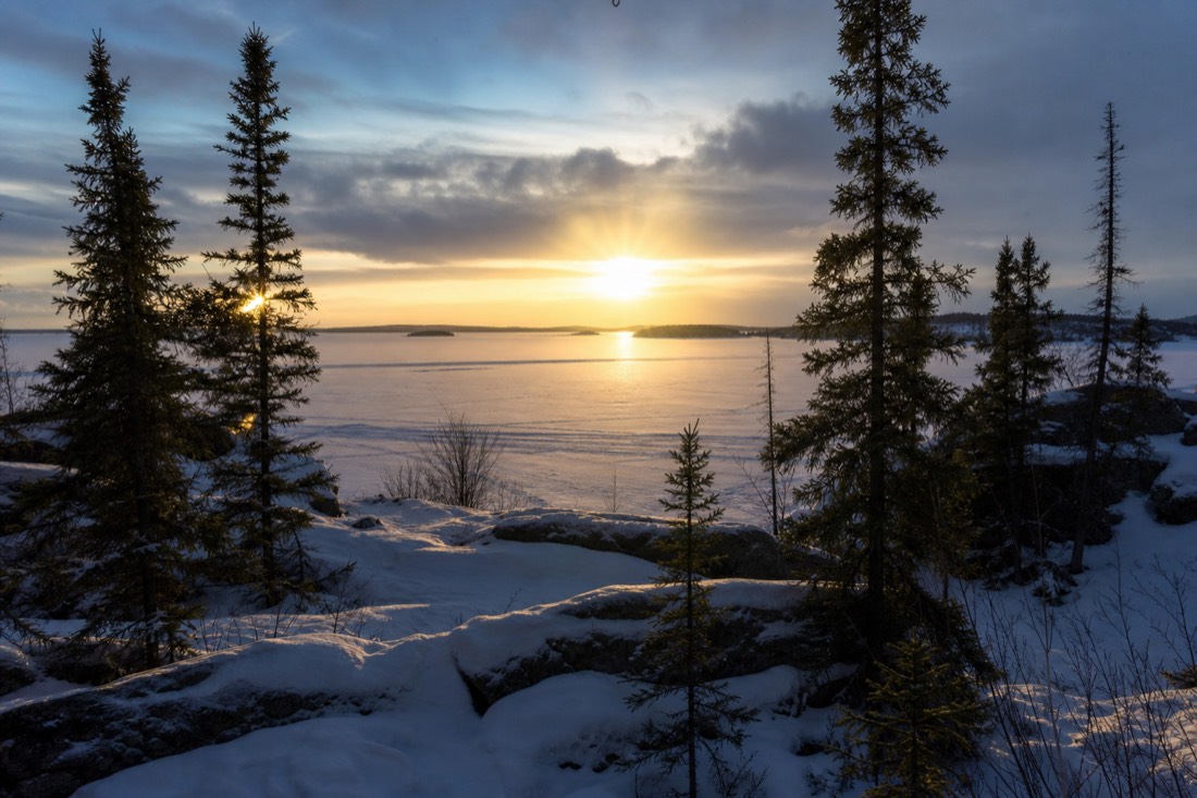 Low winter sun over the frozen Yellowknife Bay seen from the Old Town shoreline in the early afternoon