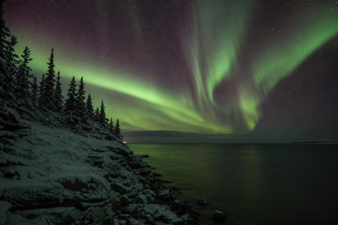 Late August aurora over open dark water as true night returns to the northern sky after summer