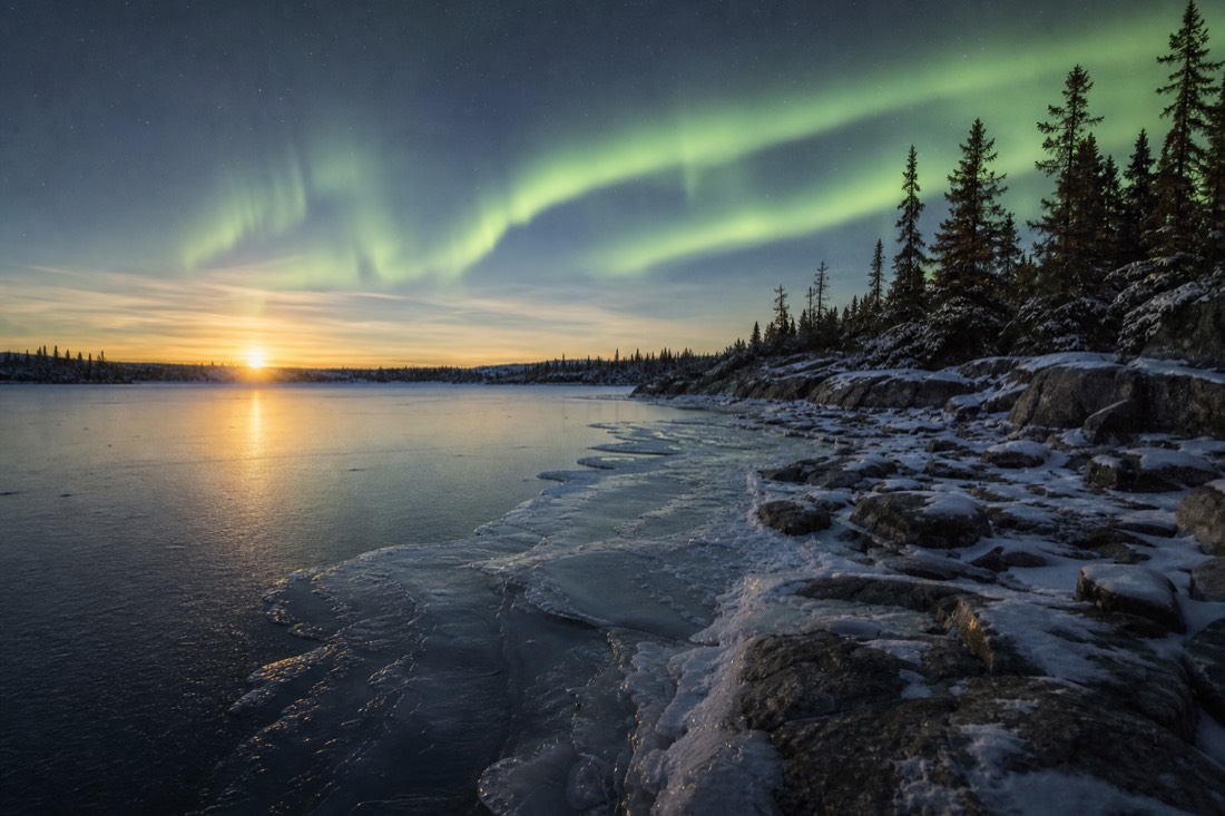 New grey ice forming along the shoreline of Yellowknife Bay under a low November sun