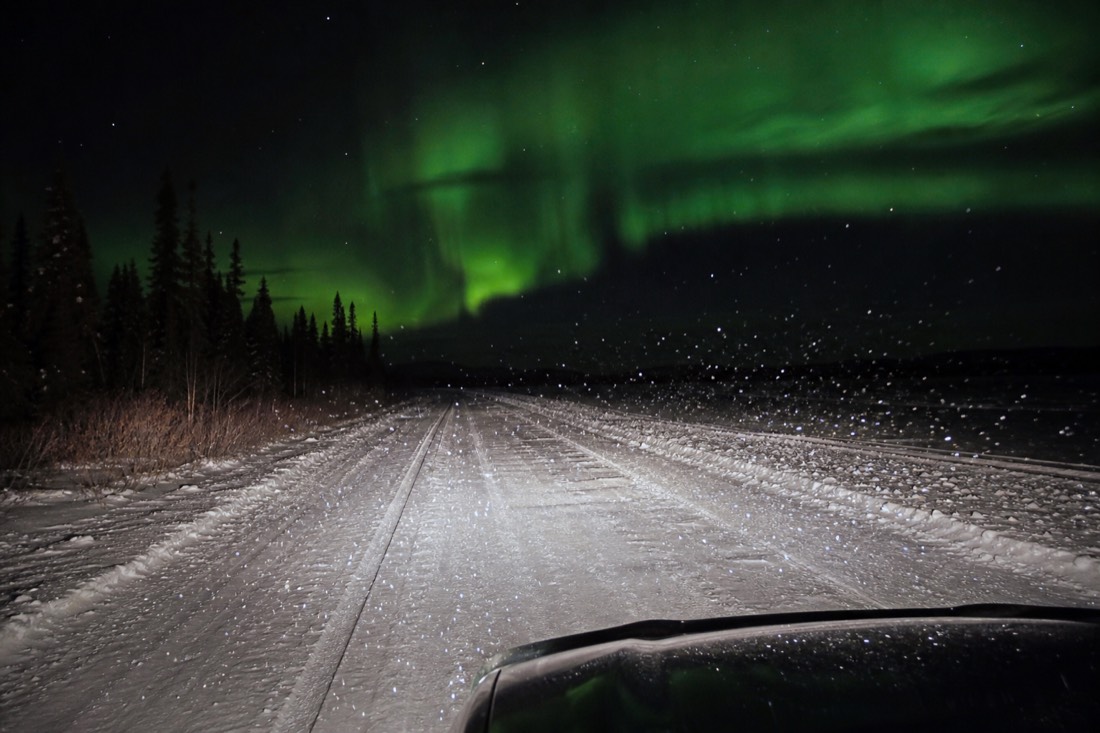 Ice crystals sparkling in headlight beams on a clear extremely cold night on a frozen lake road