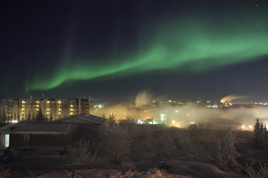 Thick ice fog rising over Yellowknife buildings at minus thirty with exhaust plumes frozen in the air